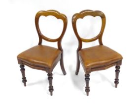 A pair of 19thC mahogany balloon back chairs, the inset seats upholstered with brown leather. Each