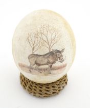 An ostrich egg with engraved decoration depicting a wild boar. Signed Fidelis lower right. Approx. 5