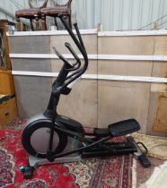 A Decathlon 'Domyos' cross trainer, with power cable and manual, approximately 75" high, 66" long