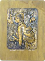 A copper plaque depicting a mother and child. Signed under 'Handmade in S Rhodesia... Vera Maw'.