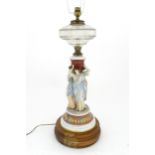 A table lamp formed from an oil lamp with ceramic figural base. Approx. 22" high Please Note - we do