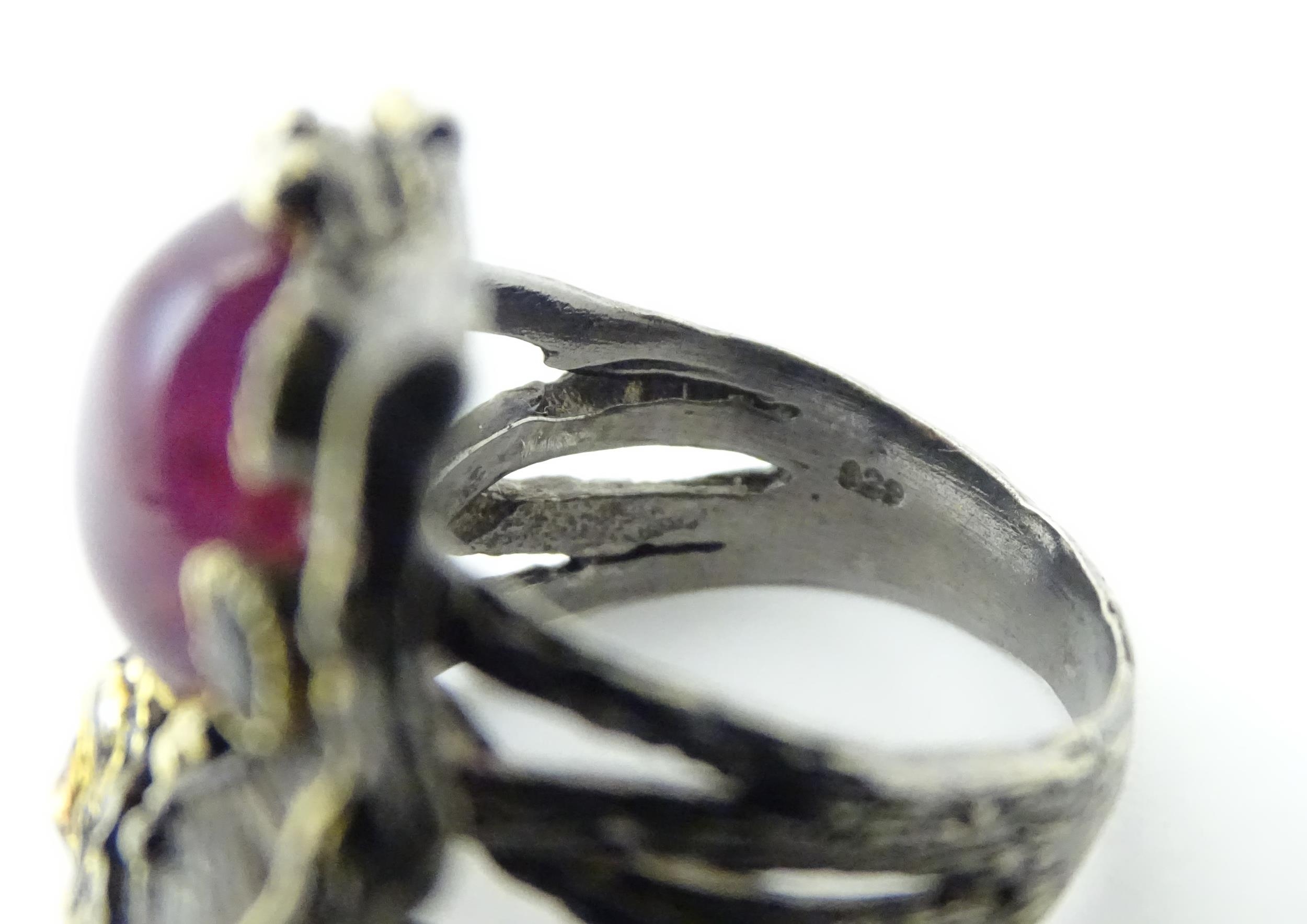 A silver ring set with ruby cabochon and two amethysts, with gilt highlights. Ring size approx. O - Image 2 of 5