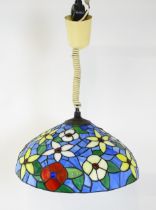 A Tiffany style light shade with floral stained glass style detail and rise and fall style light