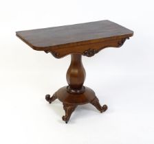 A 19thC mahogany tea table with a carved floral front panel above a canted and shaped pedestal above