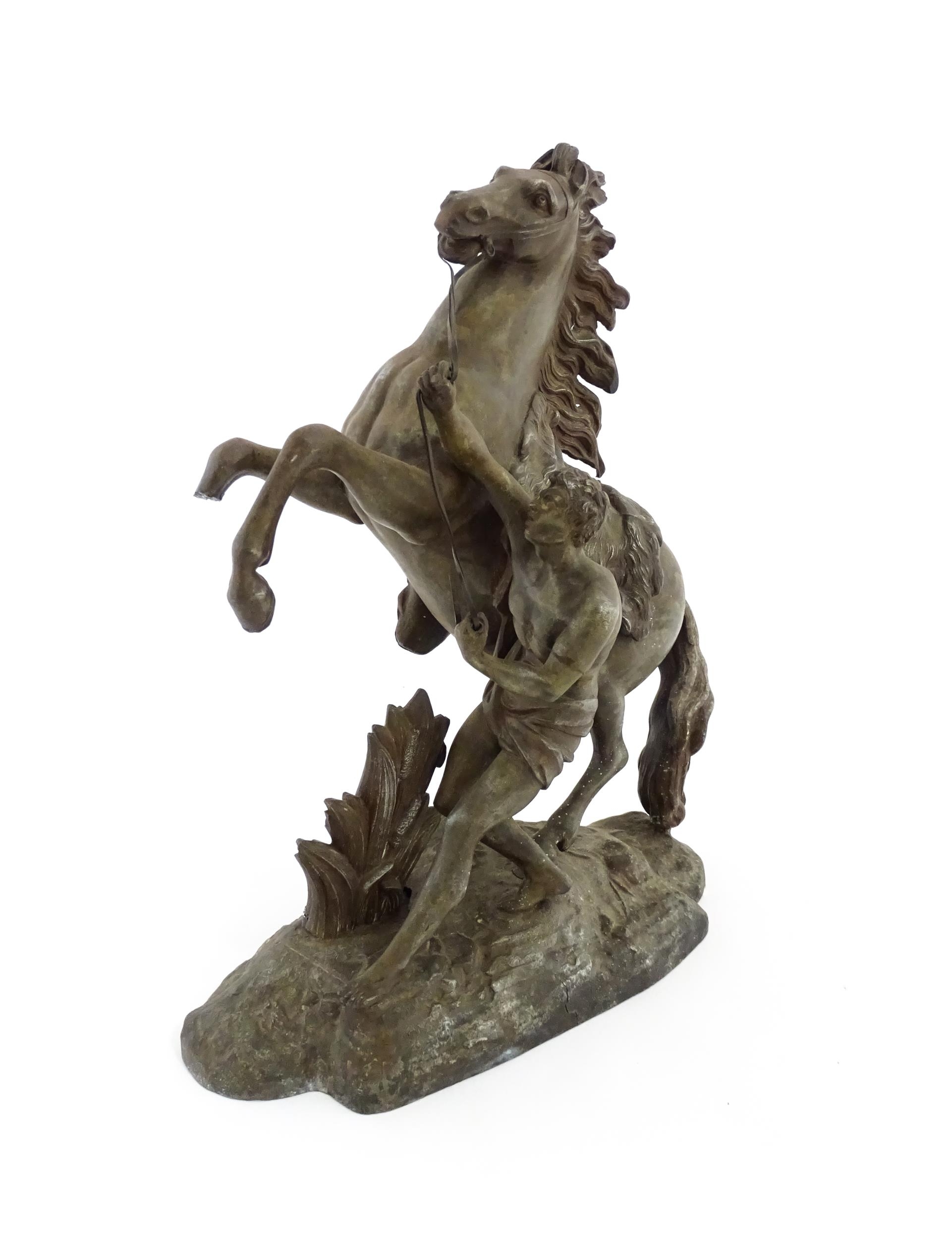 A 20thC cast Marly Horse modelled as a rearing horse with male attendant, after Guillaume Coustou I.