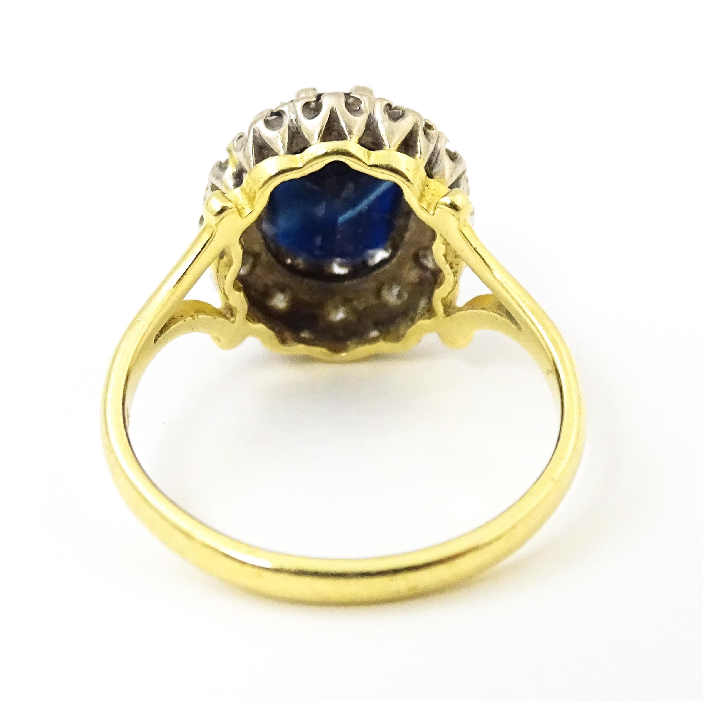 An 18ct gold ring set with central sapphire bordered by diamonds. Ring size approx. L 1/2 Please - Image 2 of 7