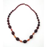 A long bead necklace of graduated cherry amber coloured beads with facet bead detail . Approx 42"