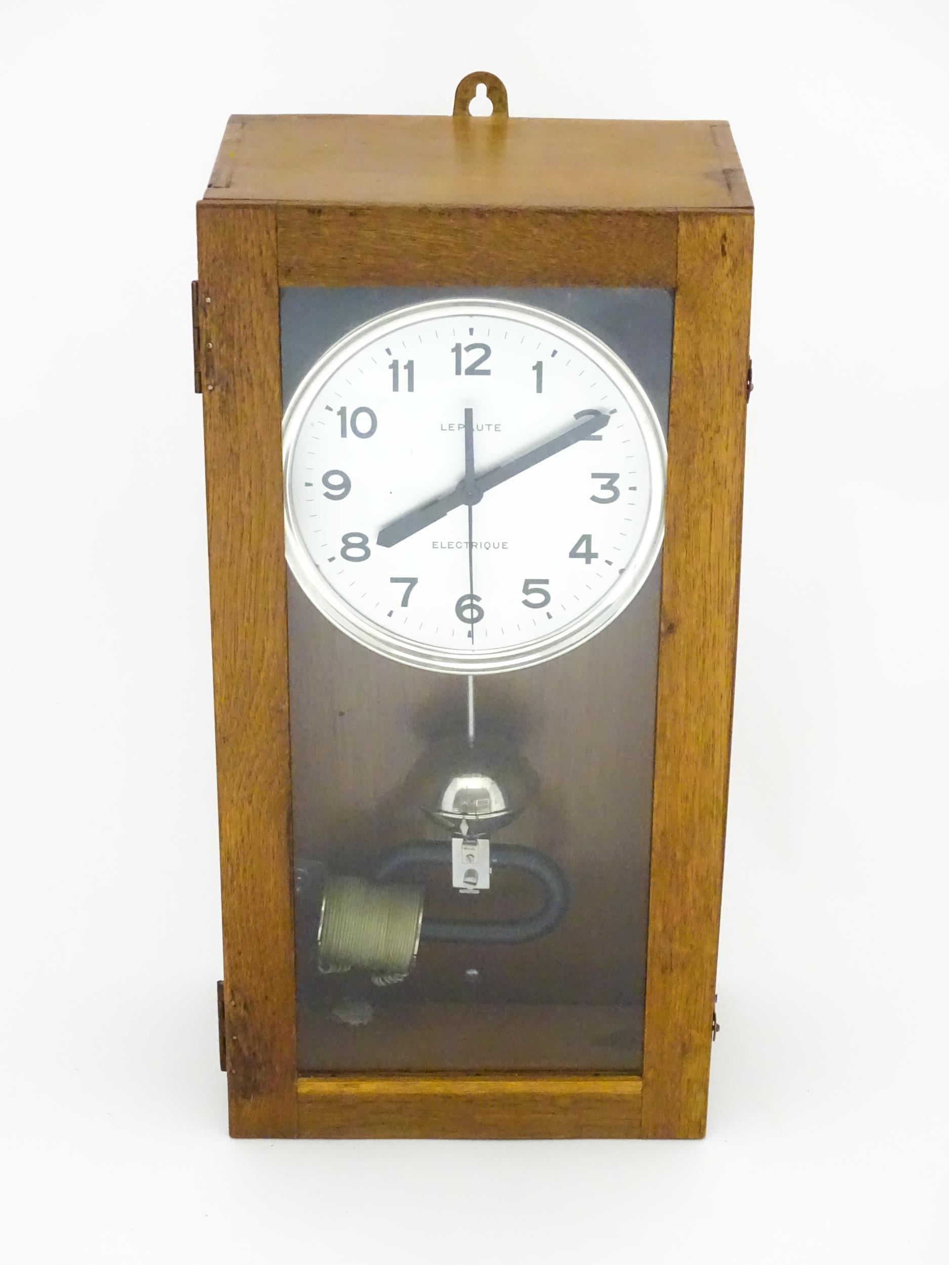 Lepaute : An early 20thC oak cased electric clock. The white dial with Arabic numerals signed