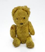 Toy: An early 20thC straw filled teddy bear with stitched nose and articulated limbs. Approx. 7"