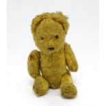 Toy: An early 20thC straw filled teddy bear with stitched nose and articulated limbs. Approx. 7"