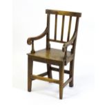 A Georgian child's chair with reeded back slats, scrolled arms and raised on tapering legs united by