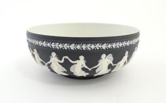 A Wedgwood black Jasperware bowl decorated with Classical maidens / Dancing Hours. Marked under.