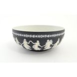 A Wedgwood black Jasperware bowl decorated with Classical maidens / Dancing Hours. Marked under.