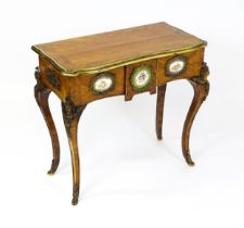 A mid 19thC kingwood side table with a brass moulding to the top edge and three Sevres style plaques