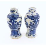 A pair of Chinese blue and white vases decorated with flowers and foliage. Blue ring marks under.