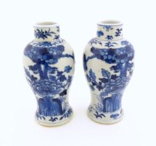 A pair of Chinese blue and white vases decorated with flowers and foliage. Blue ring marks under.