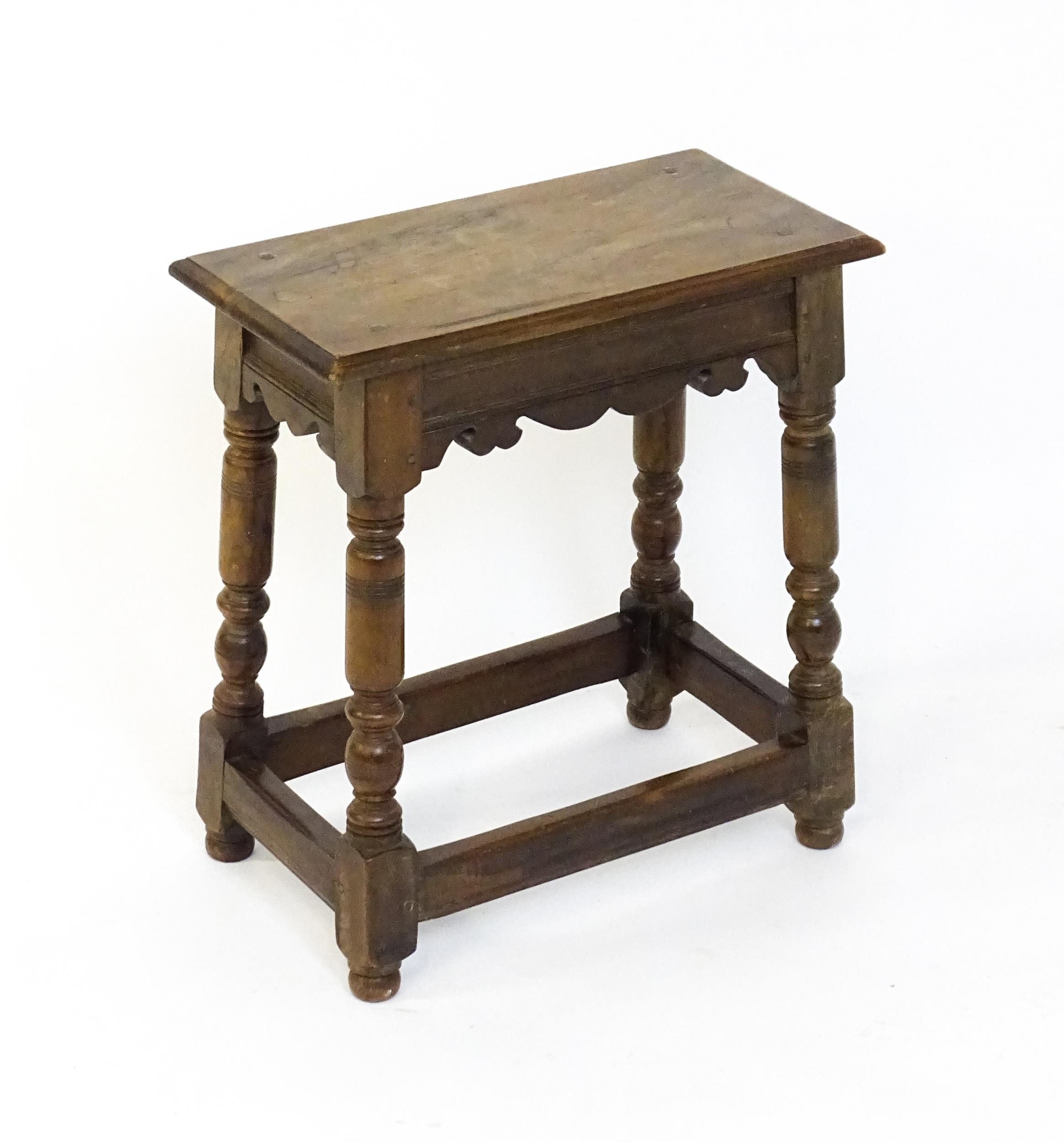 A 19thC walnut join stool of peg jointed construction, with a rectangular top above a moulded