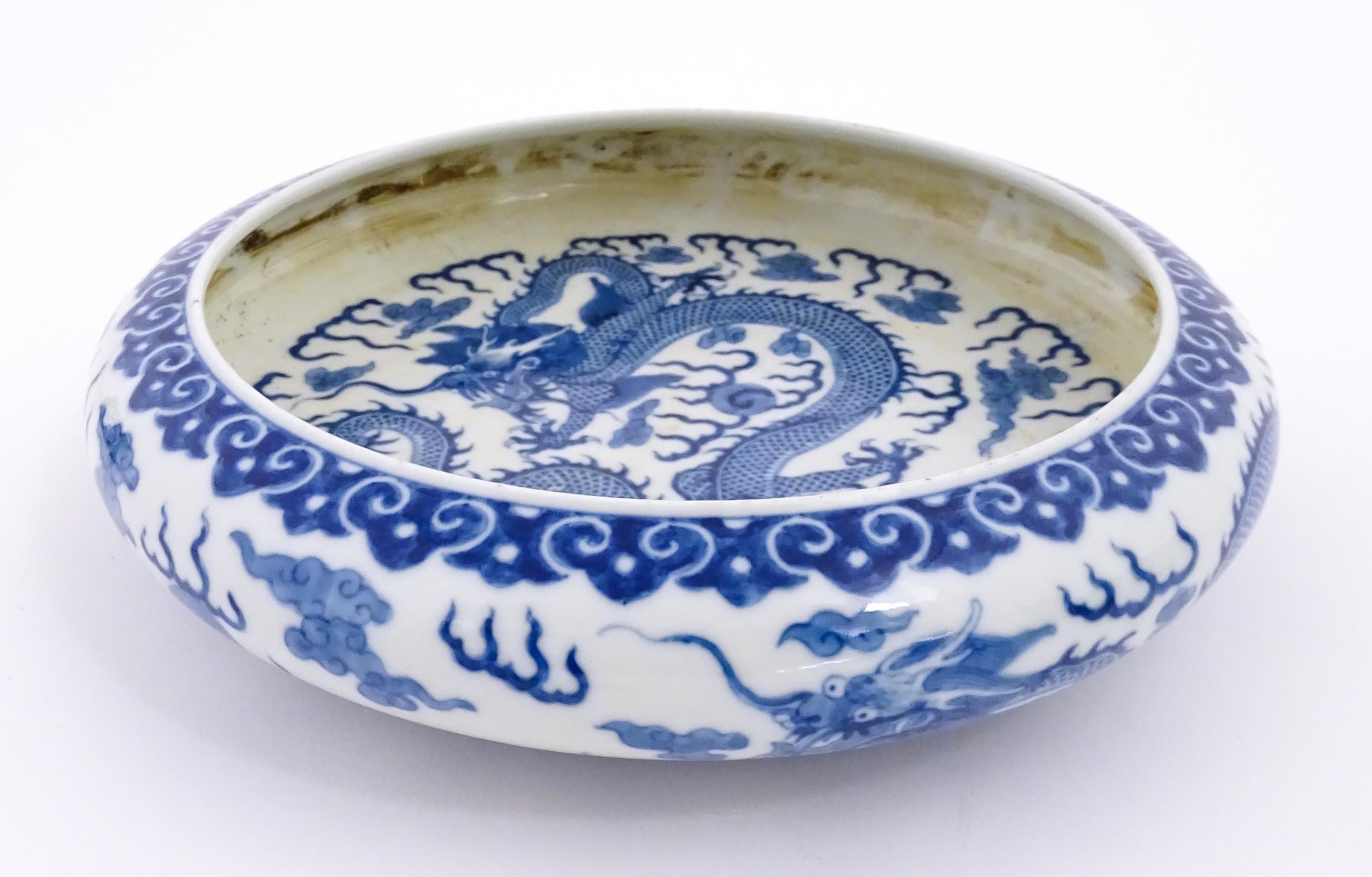 A Chinese blue and white dish decorated with dragons amidst clouds. Character marks under. Approx.