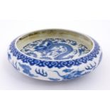 A Chinese blue and white dish decorated with dragons amidst clouds. Character marks under. Approx.