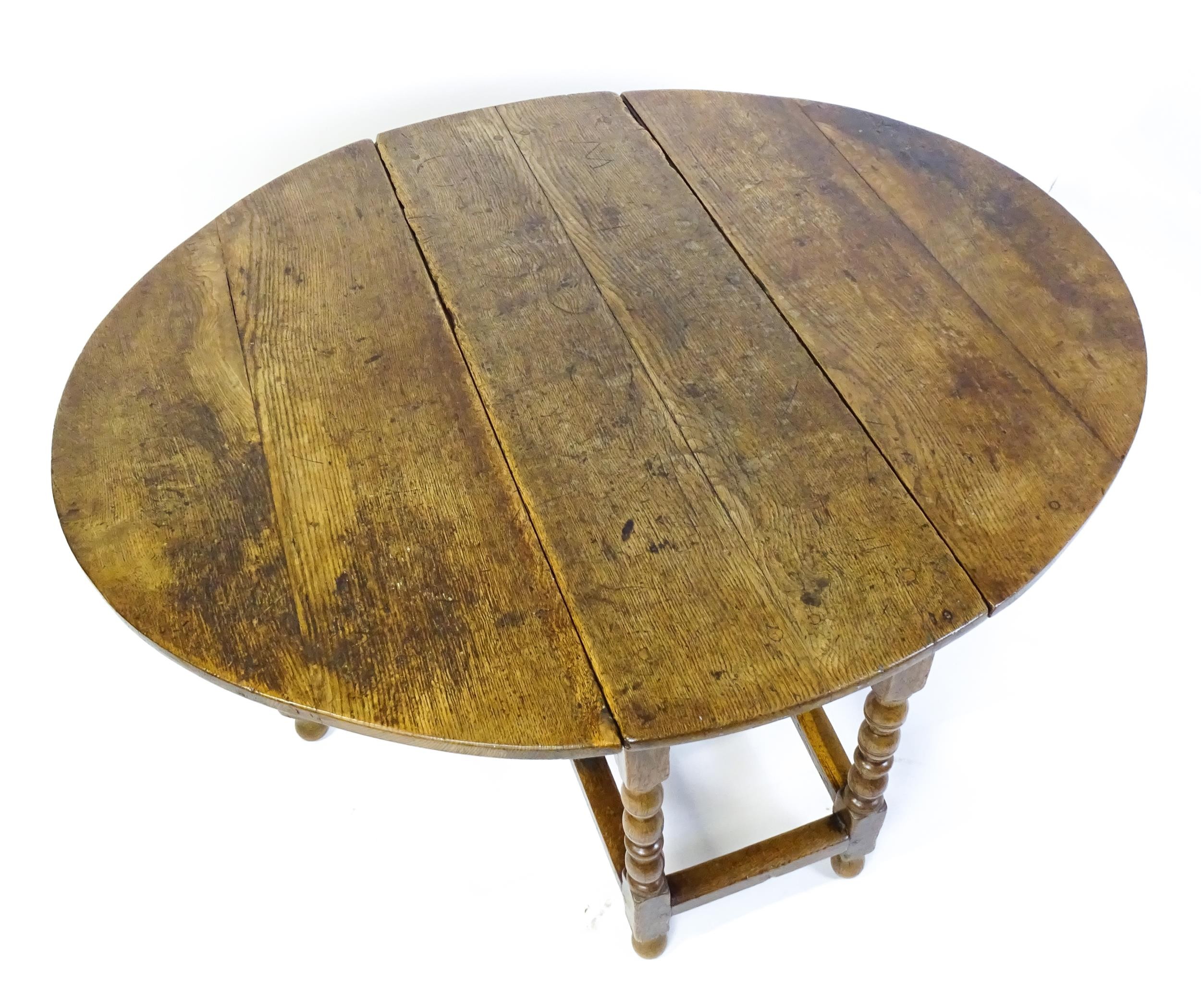 An early 18thC oak drop leaf table of large proportions, the table having two demi lune leaves and - Image 4 of 6