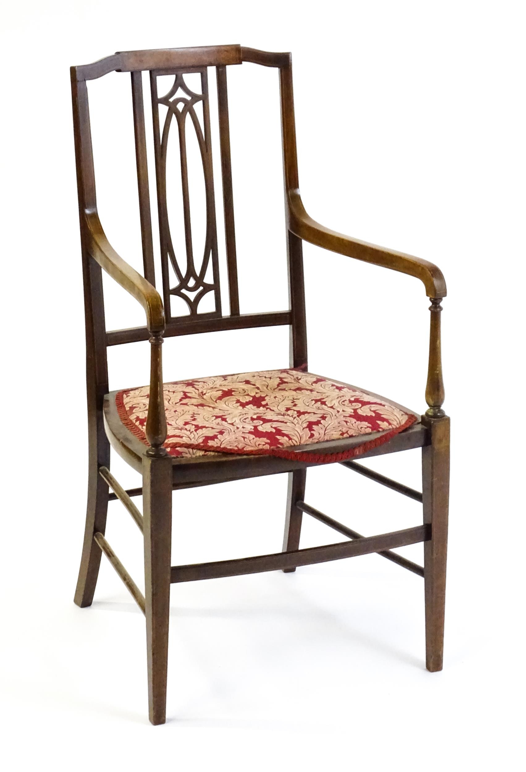 An Edwardian elbow chair with a burr walnut veneered top rail, a pierced back splat and swept arms