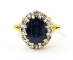 An 18ct gold ring set with central sapphire bordered by diamonds. Ring size approx. L 1/2 Please