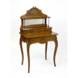 A 19thC mahogany Bonheur du jour with a shaped and mirrored upstand having marquetry decoration