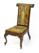 A mid 19thC rosewood prie-dieu with needlework upholstery, scrolled carved detailing to the seat