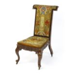 A mid 19thC rosewood prie-dieu with needlework upholstery, scrolled carved detailing to the seat