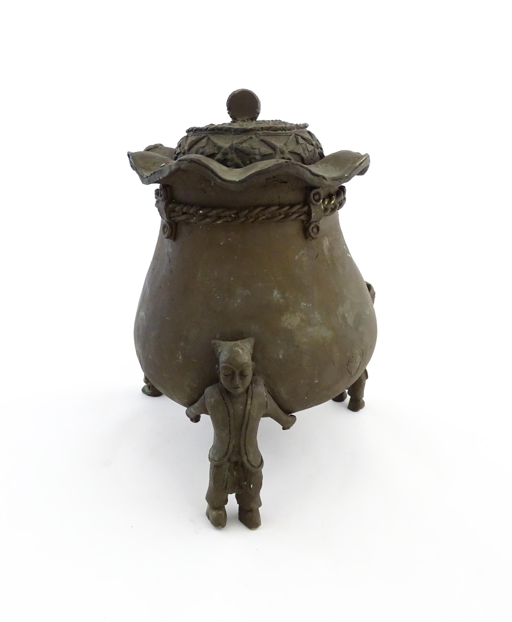 A Chinese cast bronze pot and cover modelled as a money bag with rope tie supported by three figural - Image 4 of 10