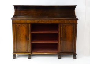A 19thC rosewood bookcase with a moulded shelf raised on two scrolled brackets, the base having