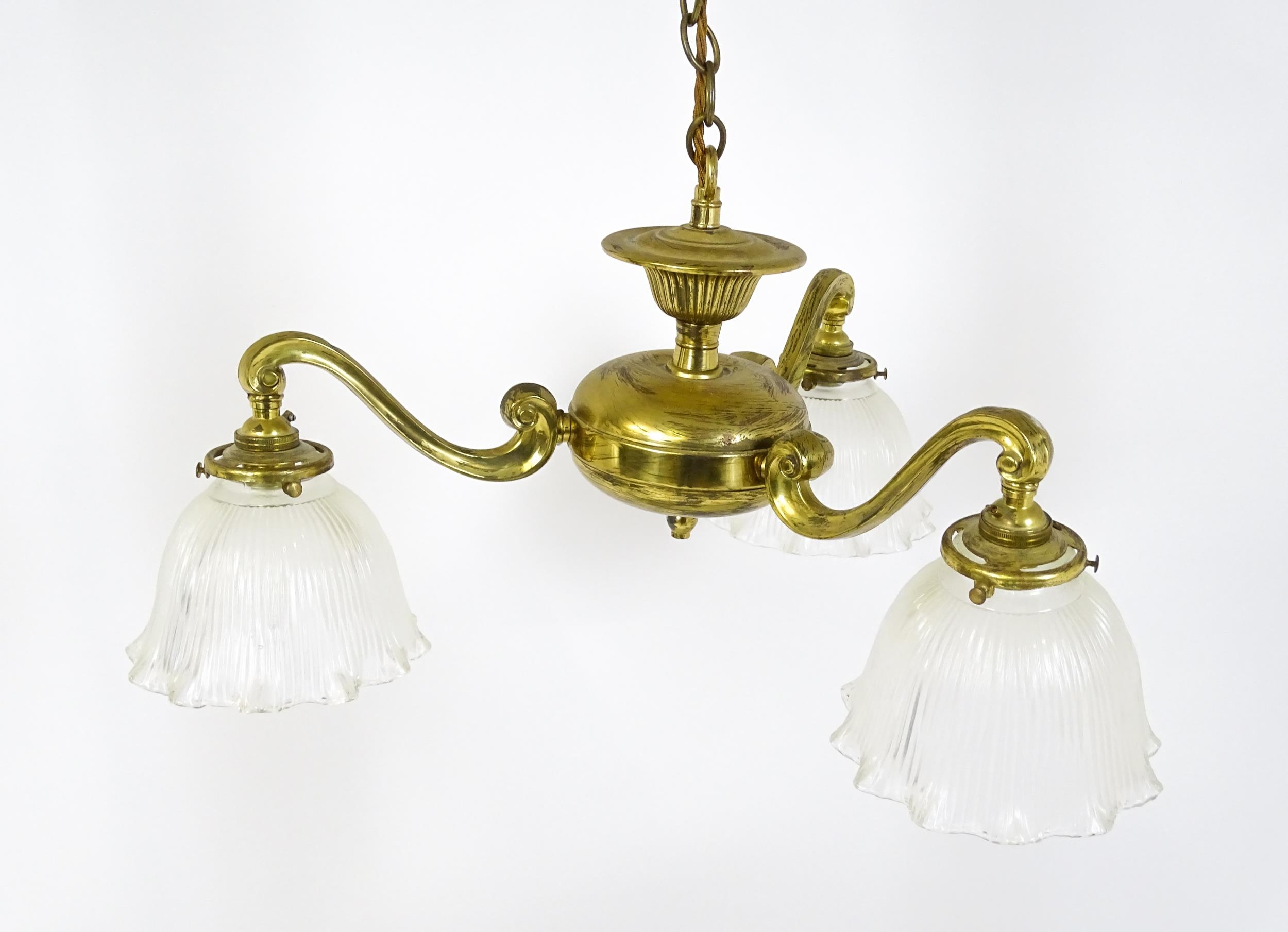 A pair of brass pendant lights having three scrolling branches with three holophane shades. - Image 12 of 16