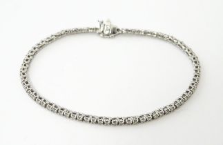 A 14ct white gold tennis bracelet set with diamonds. Approx 7 1/2" long Please Note - we do not make