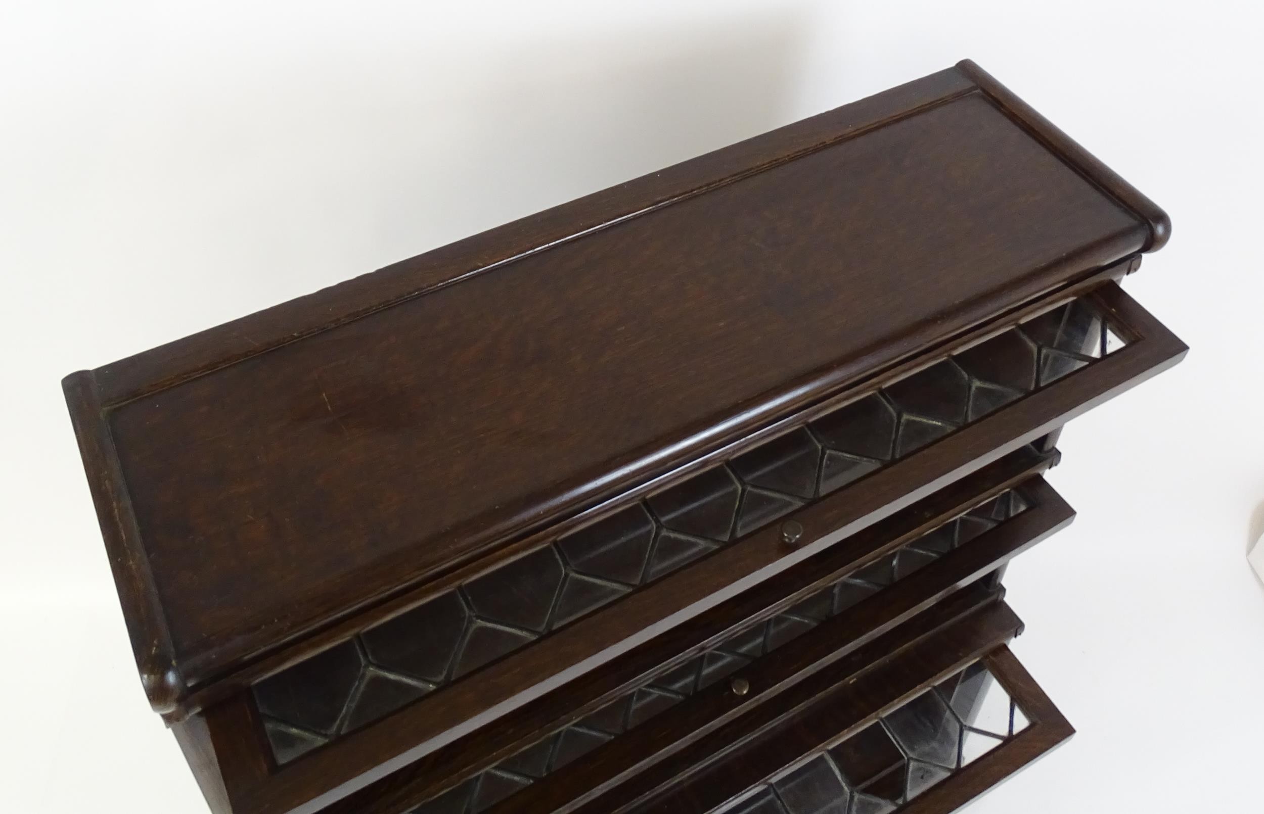 An early / mid 20thC oak Globe Wernicke bookcase with three glazed tiers above a shaped base. 34" - Image 6 of 8