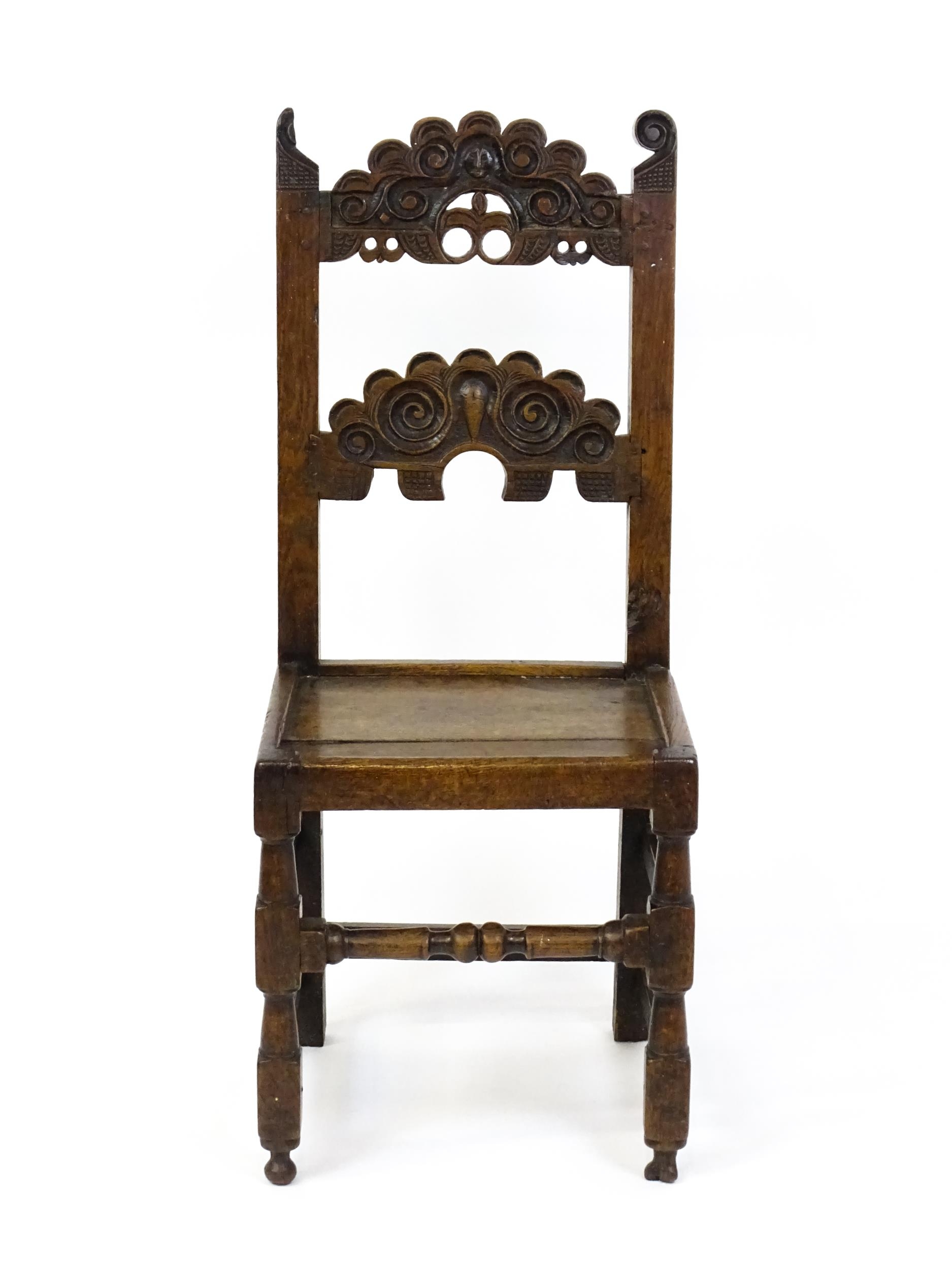 A 17thC oak peg jointed hall chair / back stool with a carved and scrolled top and mid rail raised - Image 3 of 7