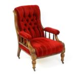 A late 19thC mahogany armchair, with deep buttoned upholstery and manchettes raised on turned