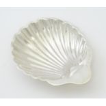A silver butter dish of scallop shell form hallmarked Birmingham 1902, maker William Aitken. Approx.