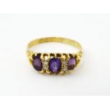 An 18ct gold ring set three graduated amethyst and four diamonds. Ring size approx. Q Please
