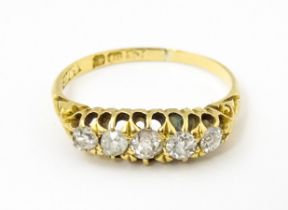 An 18ct gold ring set with five diamonds. Ring size approx. L Please Note - we do not make reference