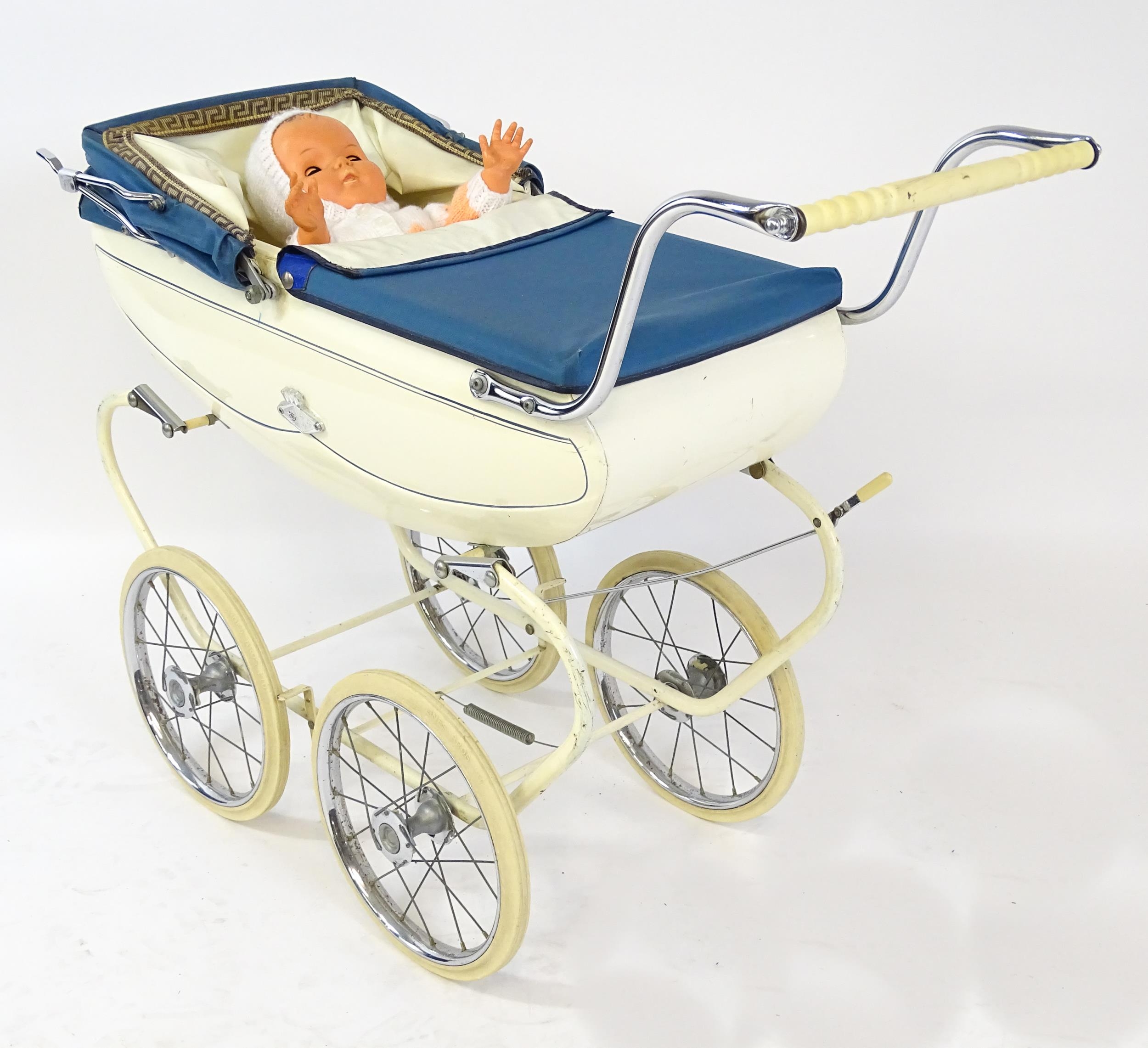 Toys: A 20thC Pedigree dolls pram with cream exterior and blue hood. Together with a plastic doll - Image 3 of 11