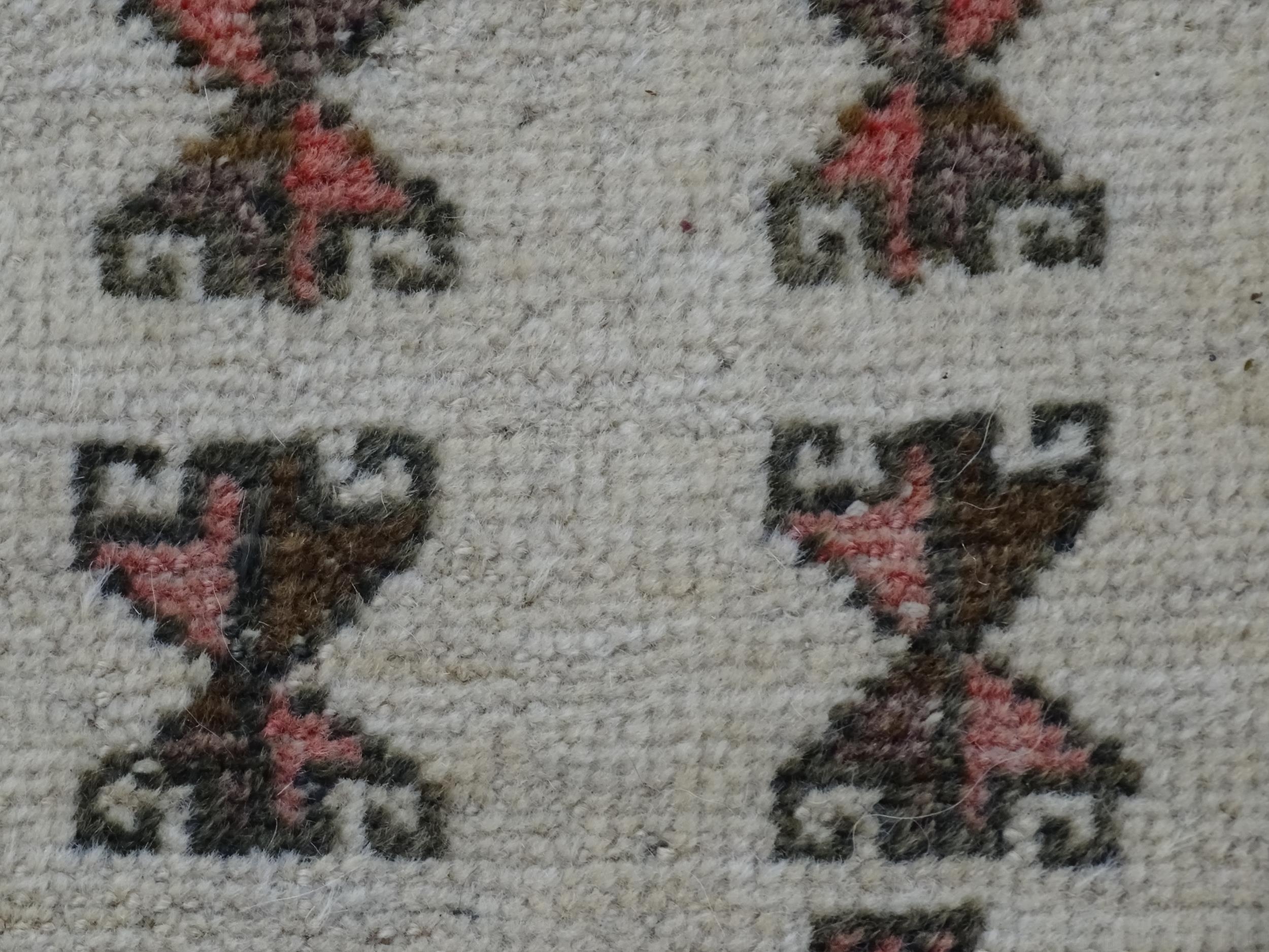 Carpet / Rug: A beige ground rug with repeated motifs worked in salmon pink, brown and beige, with - Image 9 of 9