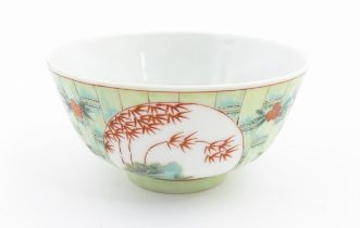 A Chinese famille verte bowl decorated with stylised bamboo and flowers. Character marks under.