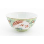 A Chinese famille verte bowl decorated with stylised bamboo and flowers. Character marks under.