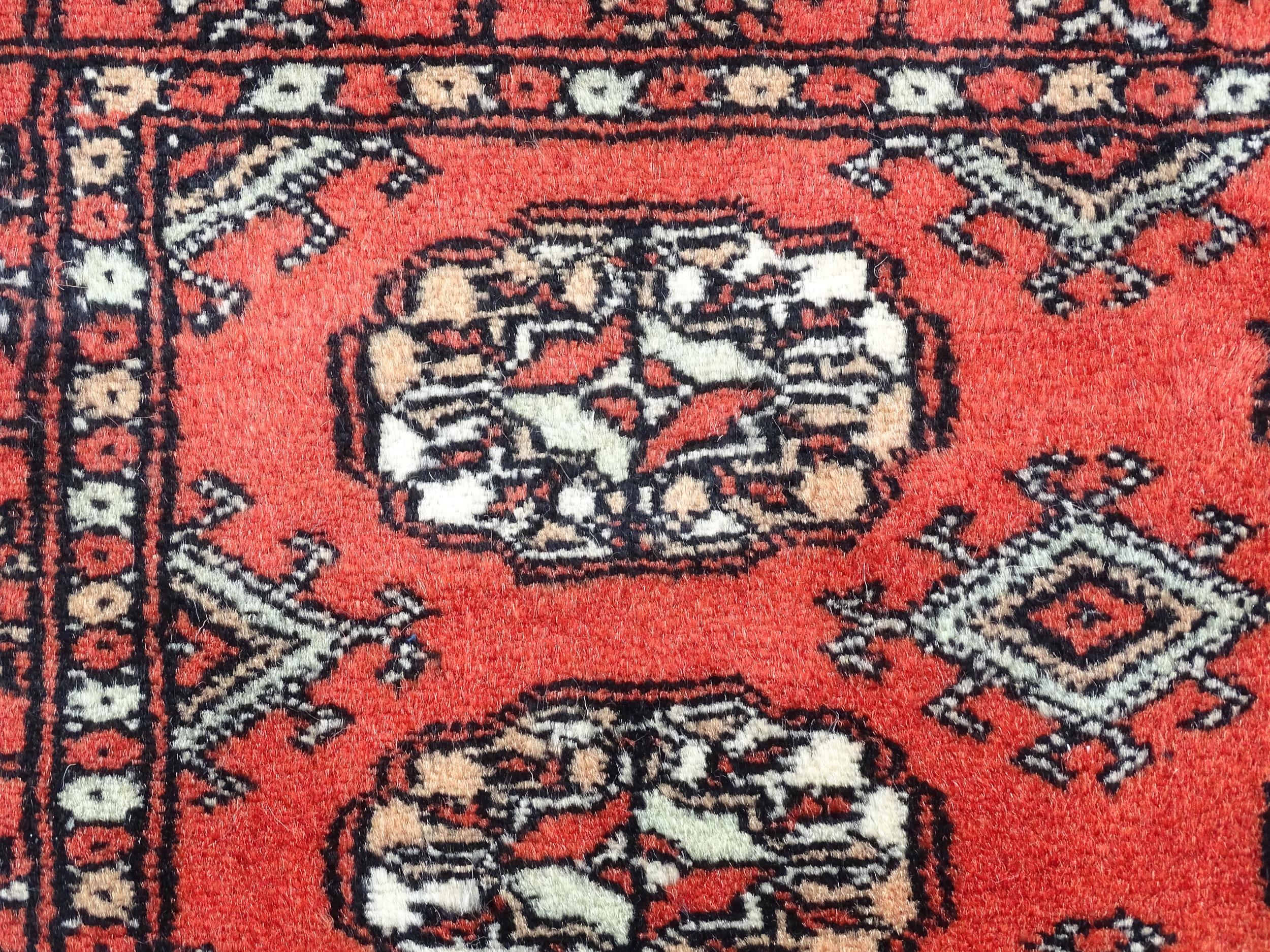 Carpet / Rug : A Pakistan wool red ground rug decorated with repeating geometric motifs with further - Image 4 of 8