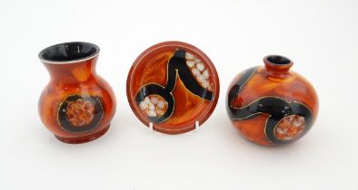 Three studio pottery items by Anita Harris to include two small bases and a dish, each with a red