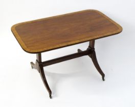 A 19thC mahogany table with a satinwood crossbanded top above twin pedestal supports and four reeded