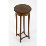 An early 20thC mahogany jardinière stand with a circular satinwood strung top raised on four