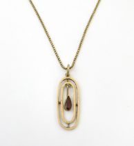 A 9ct gold chain with yellow metal pendant set with central garnet drop. Chain approx. 18" long