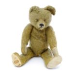 Toy: An early 20thC mohair straw filled teddy bear with proud nose, stitched mouth, hump back,