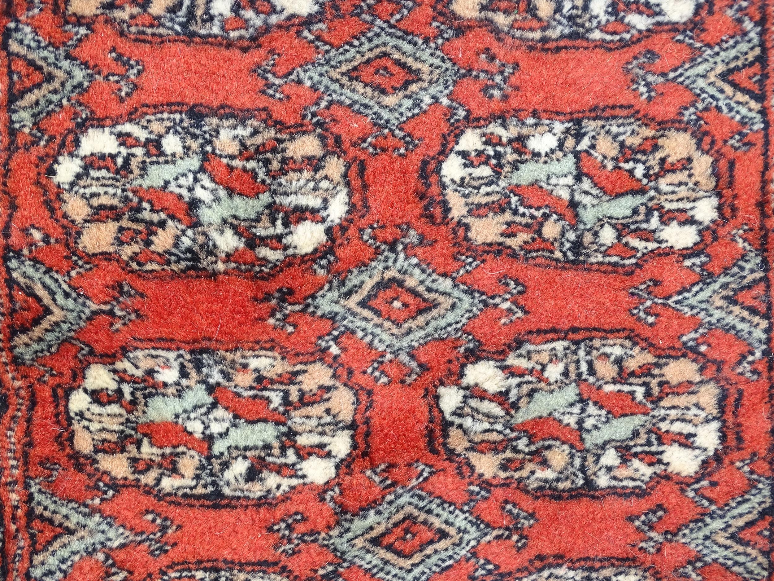 Carpet / Rug : A Pakistan wool red ground rug decorated with repeating geometric motifs with further - Image 5 of 8